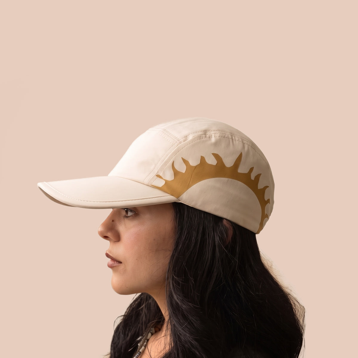 Woman wearing the cream HOJA SOL Cap in profile, sun print visible