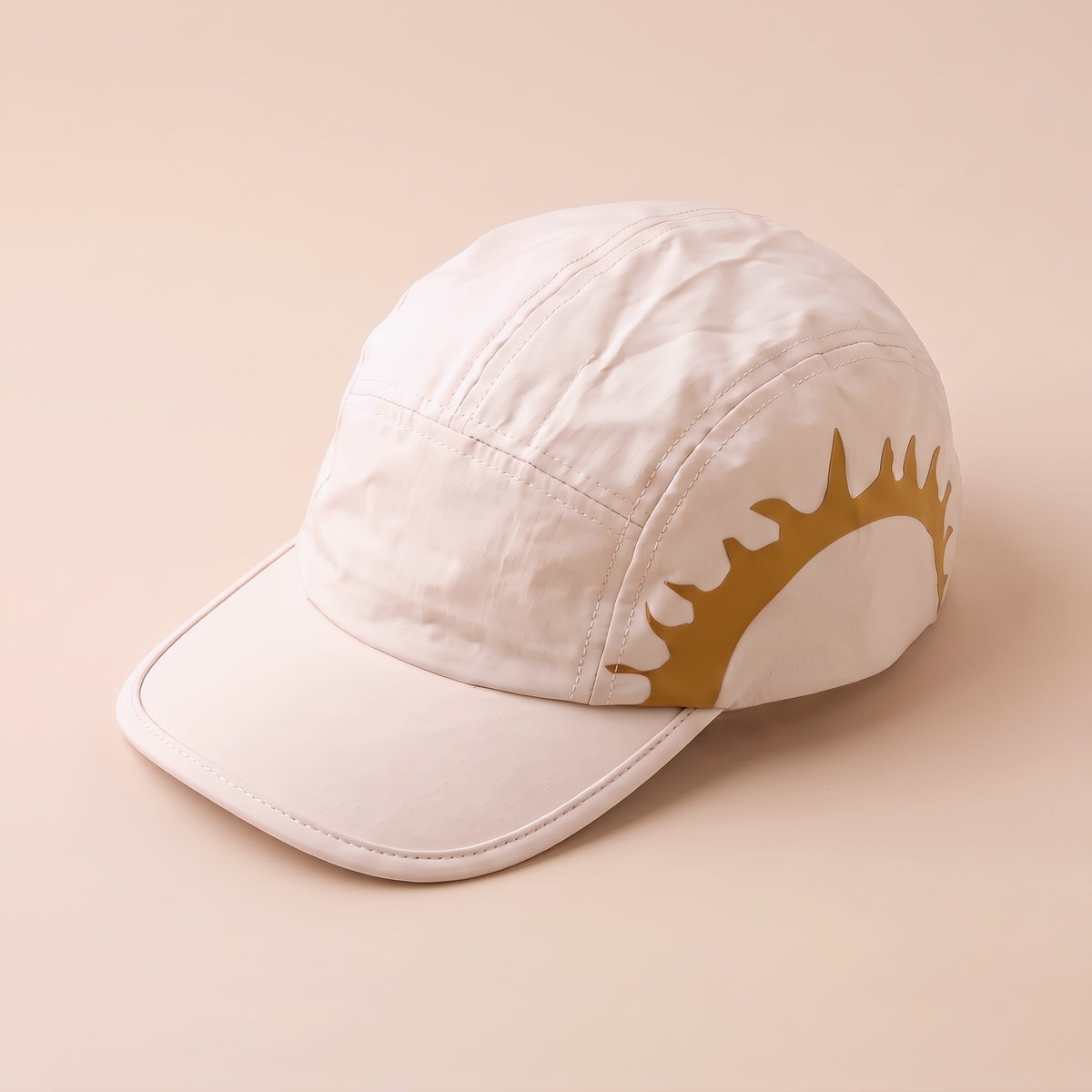 Cream HOJA SOL Cap at a three-quarter angle showing the gold sun print on the side panel